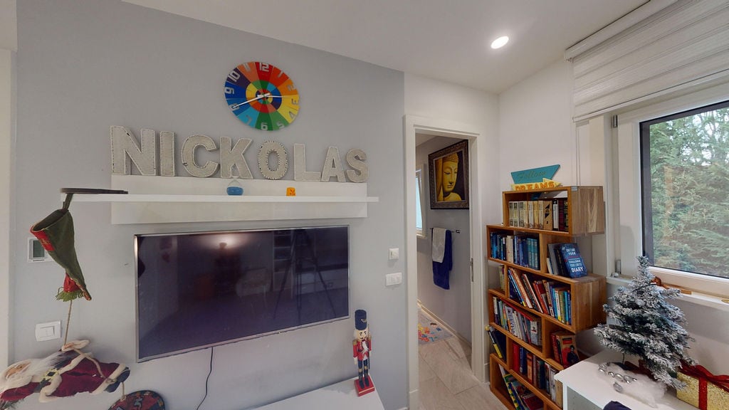 Kids' room in a townhouse, Luštica, Montenegro: TV area with shelves, bookcase, and light interior finishes.