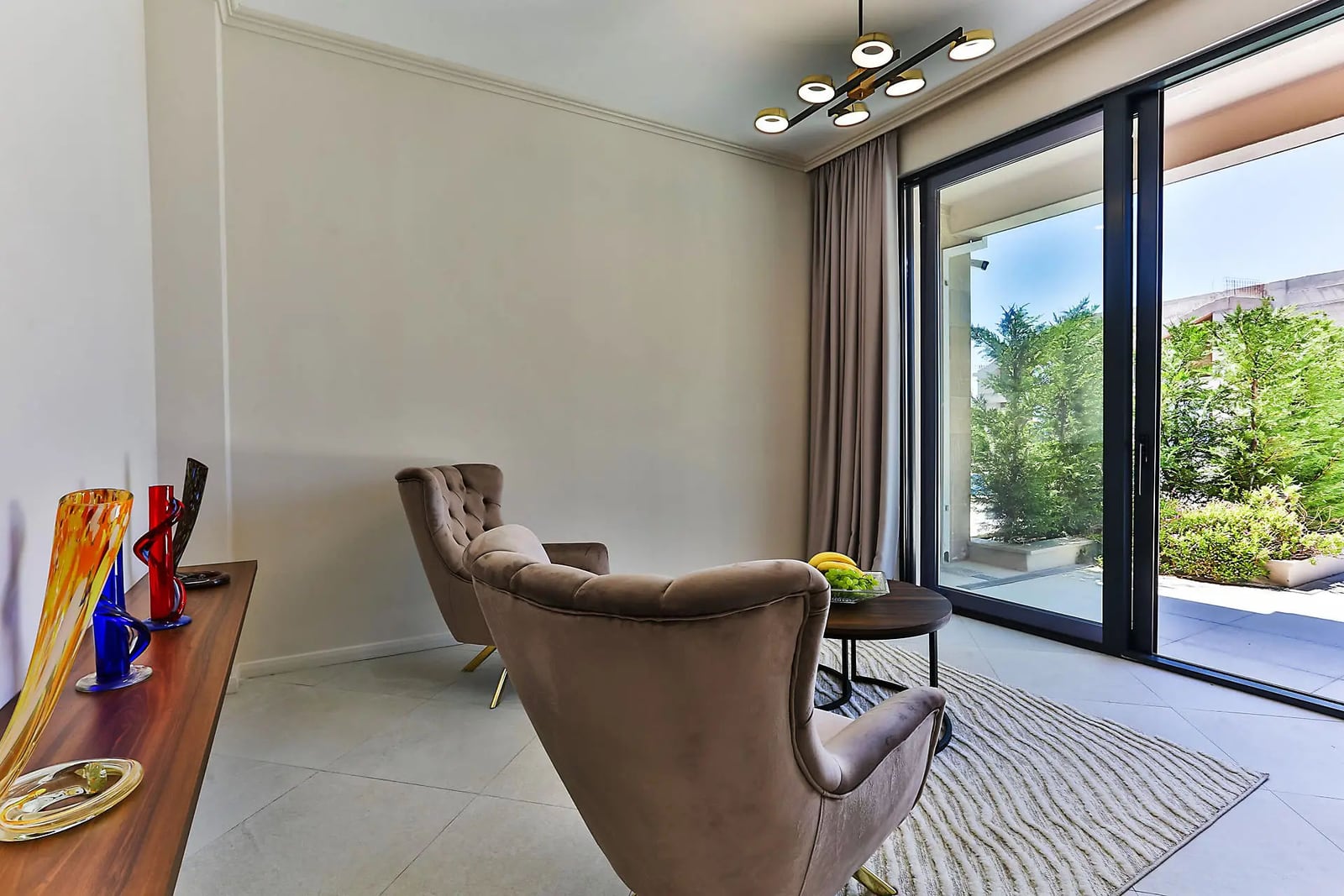 Cozy living room with plush armchairs and panoramic windows in a villa in Reževići, Montenegro. Modern interior.