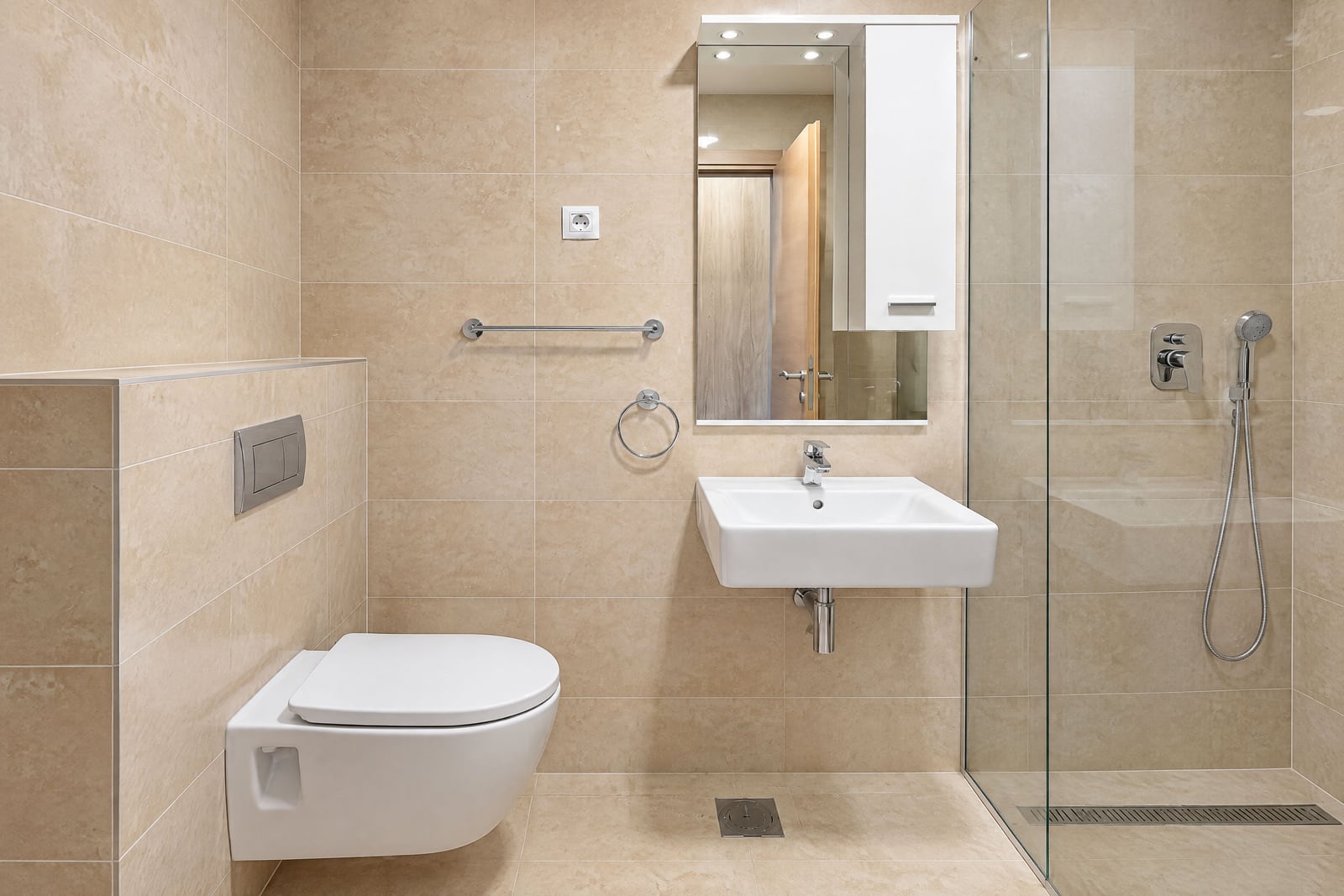Modern bathroom featuring a wall-mounted toilet, sink, mirror cabinet, and glass-enclosed shower area.