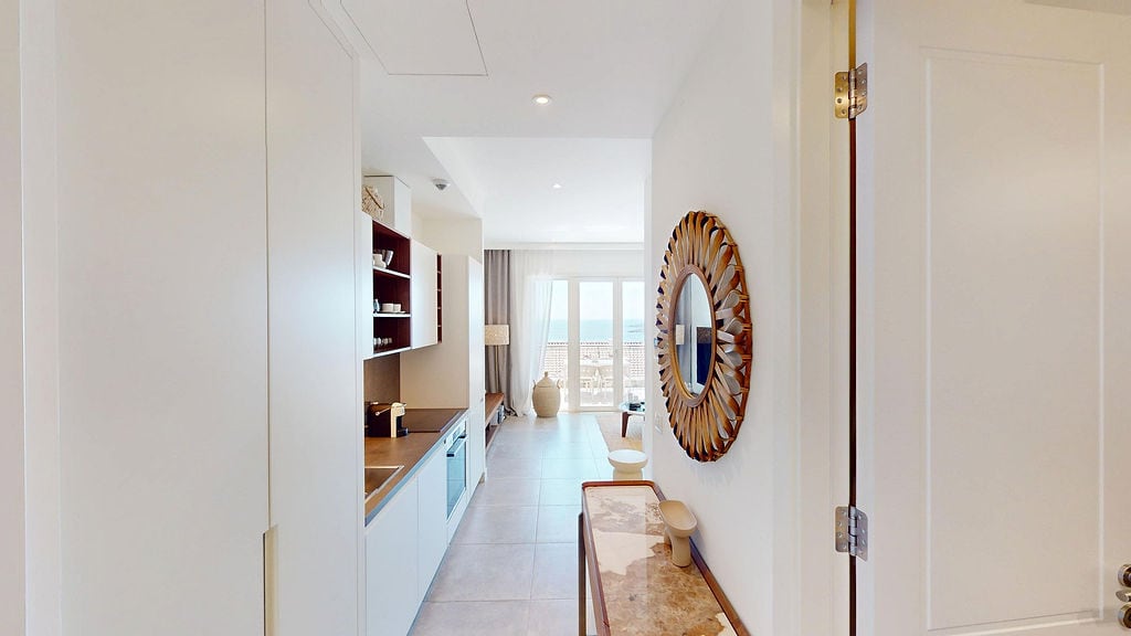 Modern kitchen in an apartment in Luštica, Montenegro: bright interior, built-in appliances, and a sea view from the window.