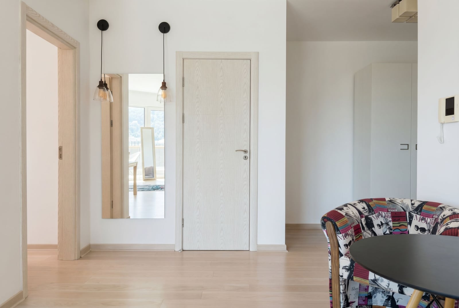 Bright living room in an apartment in Bečići, Montenegro: a stylish patterned armchair, mirror, and modern interior finishes.