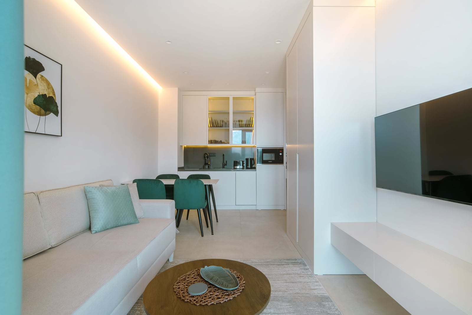 Modern living room with kitchen in an apartment, Bečići, Montenegro: bright interior, soft sofa, and dining area.