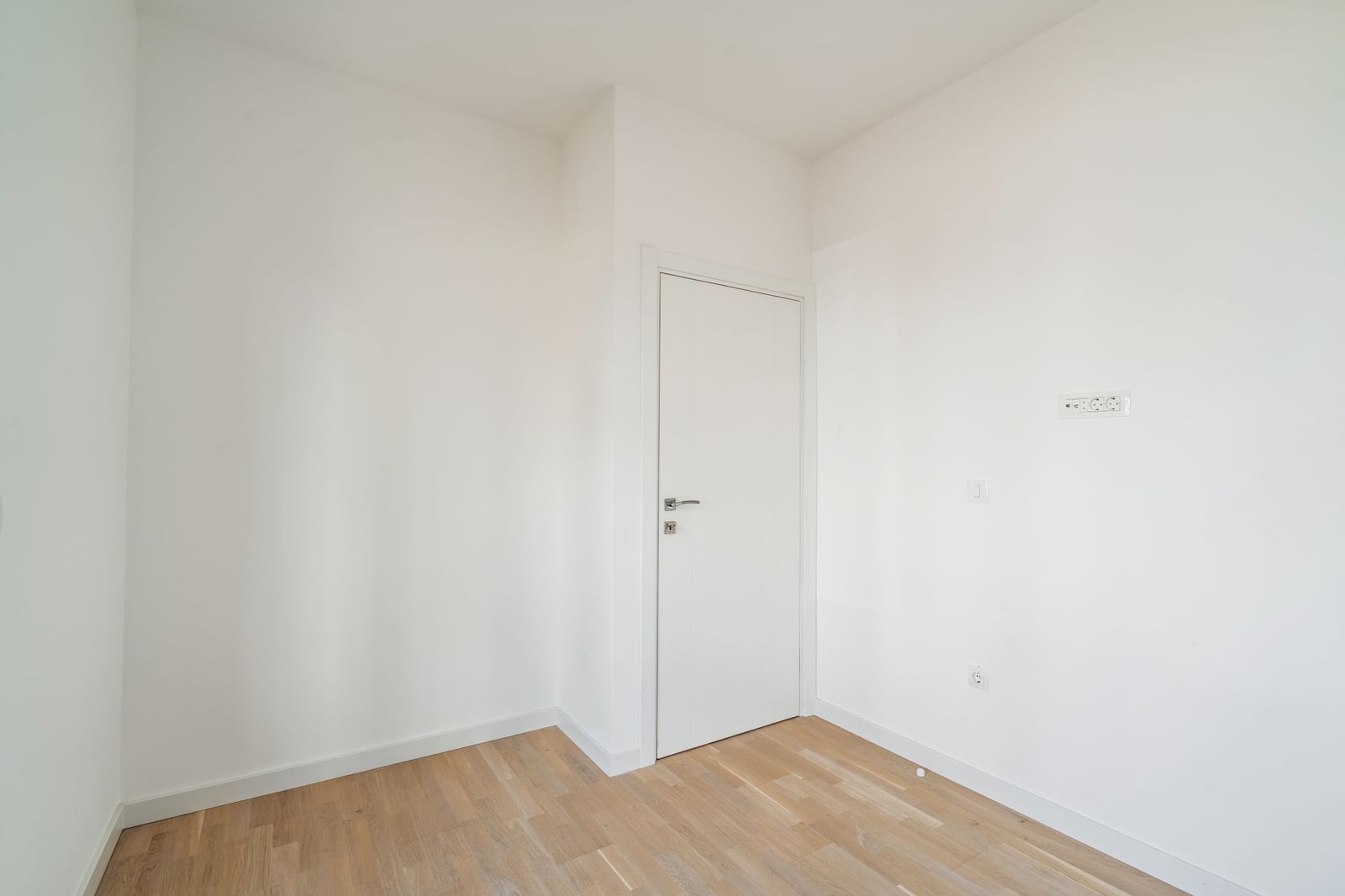 Bright empty room with white walls and parquet flooring in a residential complex, Budva, Montenegro.
