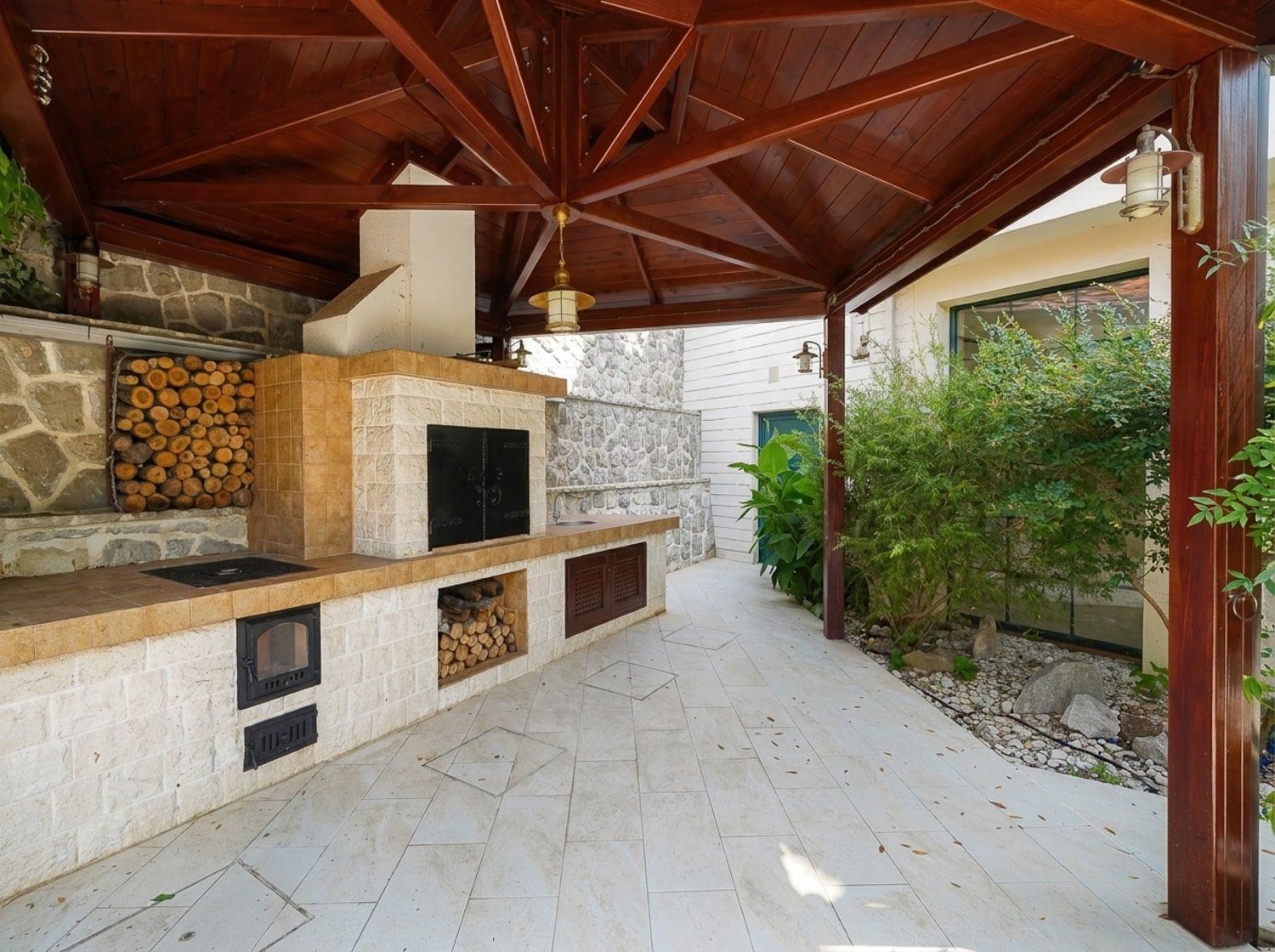Open terrace featuring a stone barbecue grill, wood storage, wooden beam roof, and tiled floor.