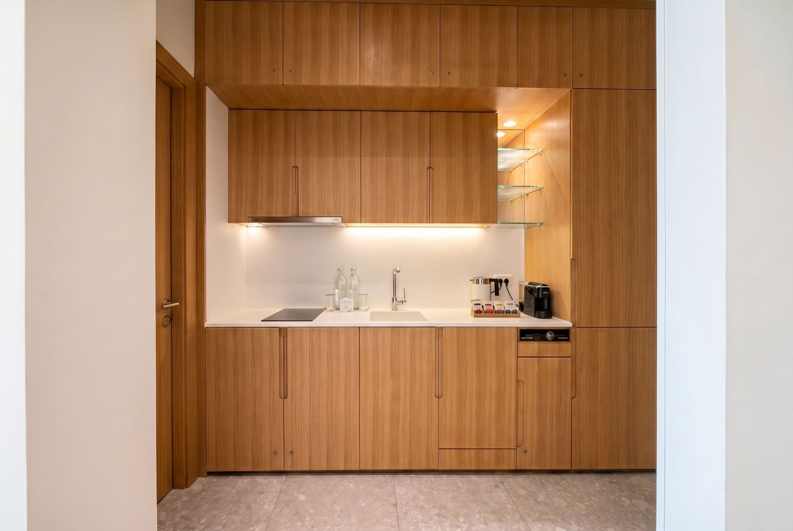 Modern kitchen with wooden cabinets and built-in appliances in a Lustica Bay apartment, Montenegro.