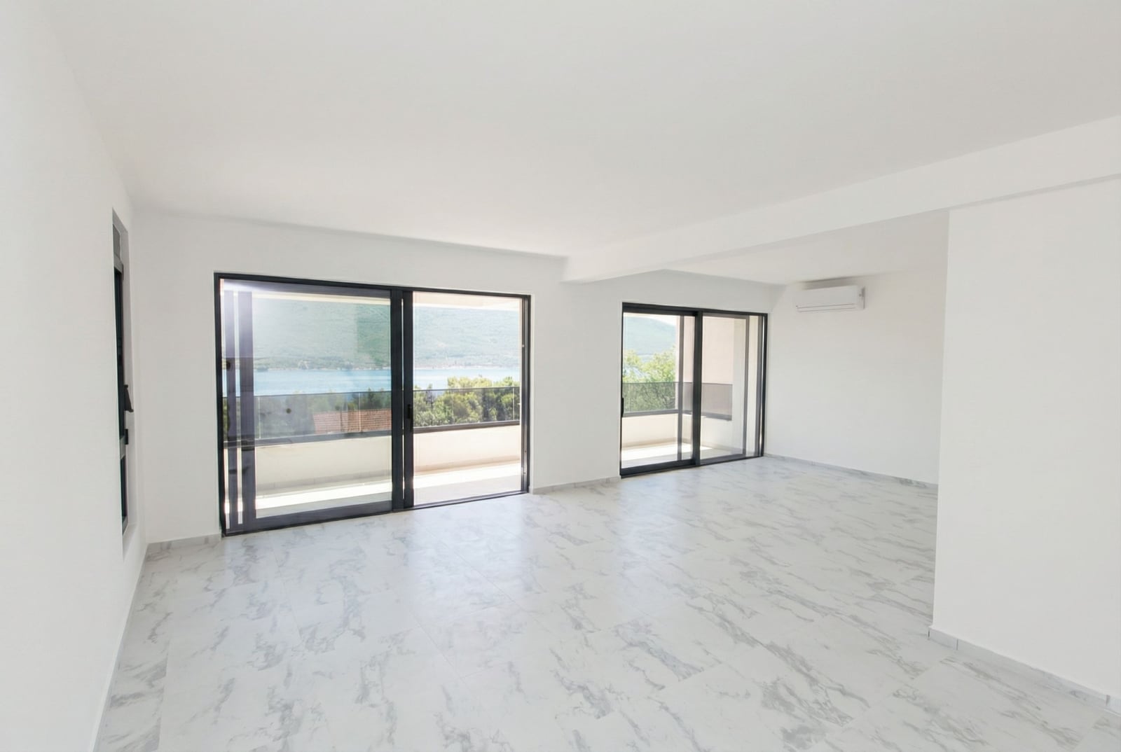 Bright living room in an apartment, Kumbor, Montenegro: panoramic windows, sea view, marble floor, and access to the terrace.