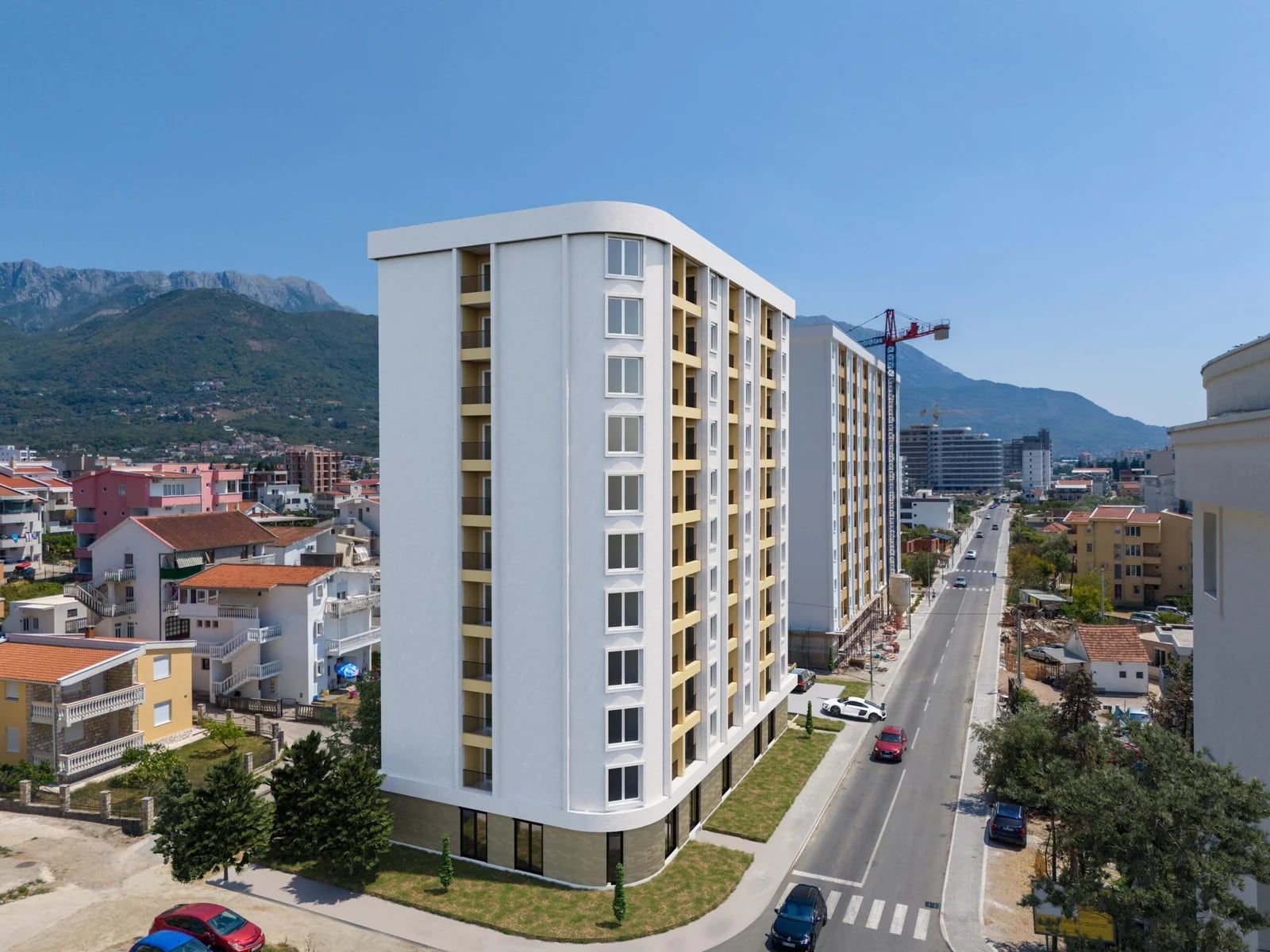 Modern residential complex in Bar, Montenegro: view of a multi-story building with balconies and a mountain landscape.