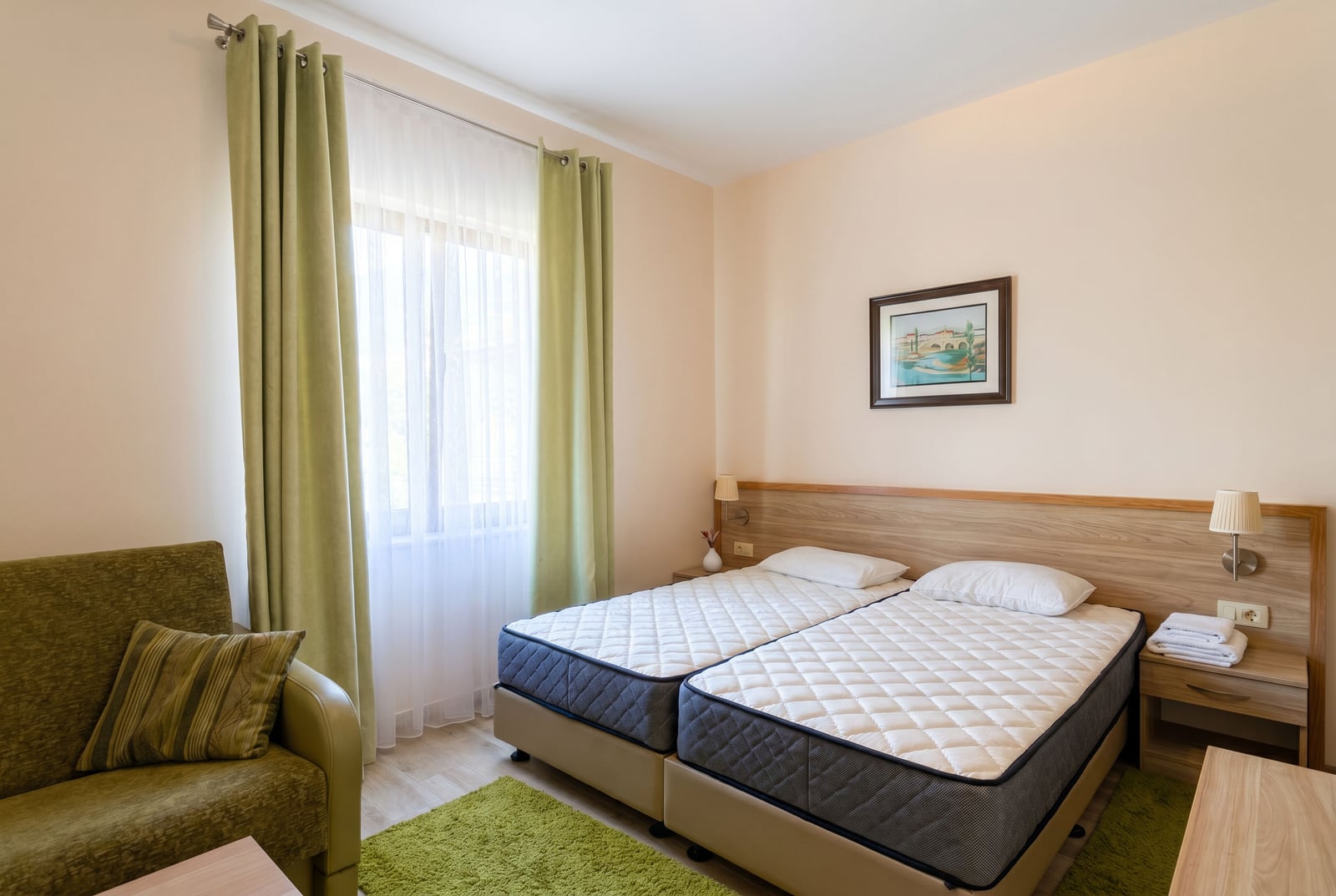 Cozy twin bedroom in an apartment, Bečići, Montenegro: bright interior, green curtains, and soft furnishings.
