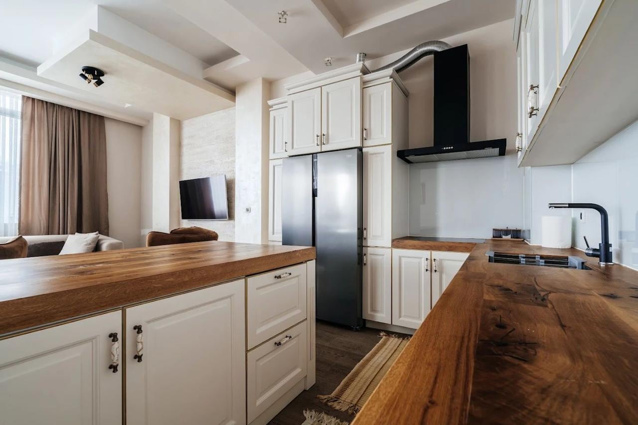 Modern kitchen with a wooden countertop and white cabinets in an apartment in Budva, Montenegro.