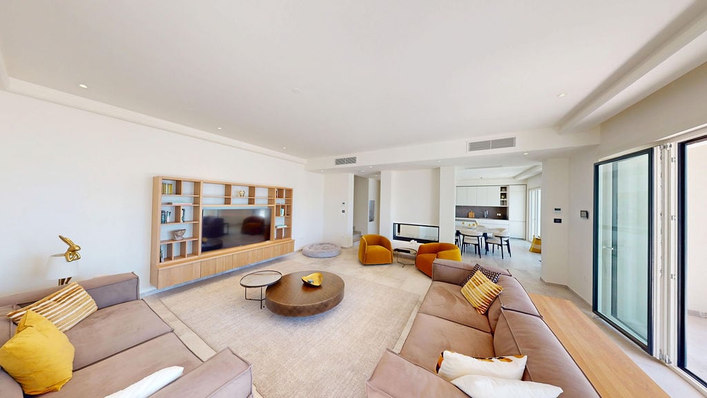 Modern living room with upholstered furniture and a fireplace in a villa in Luštica, Montenegro: stylish interior and kitchen.