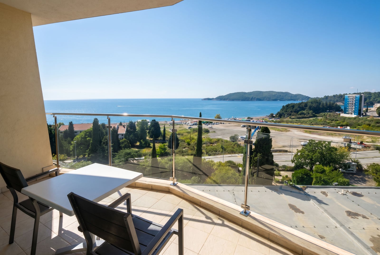 Balcony with a panoramic view of the sea and mountains in a residential complex, Becici, Montenegro. Outdoor furniture on the terrace.