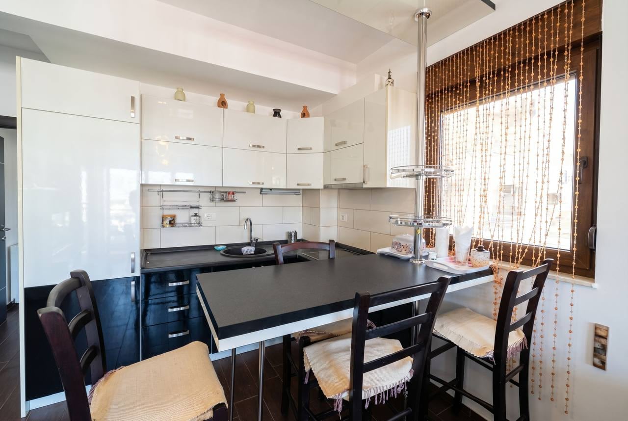 Modern kitchen with a black and white set and a bar counter in an apartment, Budva, Montenegro.