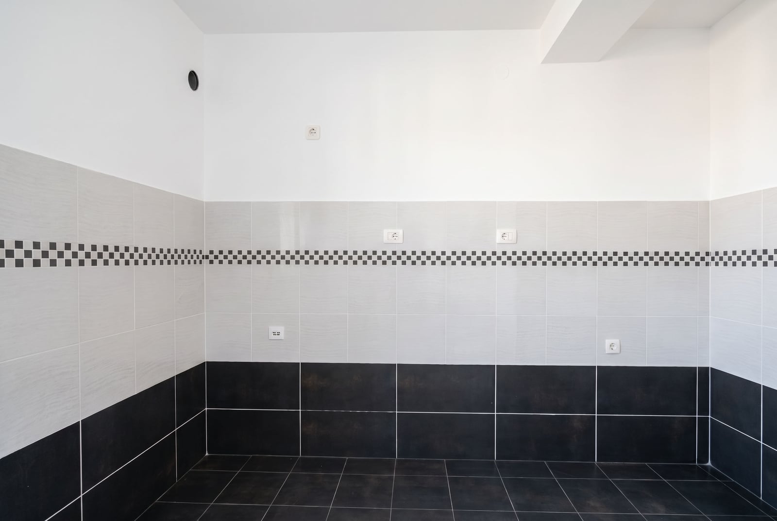 Kitchen with finished finishes, black-and-white tile, and electrical outlets in an apartment in Petrovac, Montenegro.