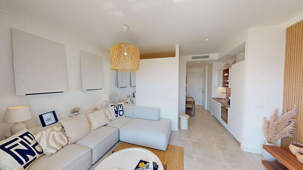 Modern living room with kitchen in an apartment in Luštica, Montenegro: bright interior, soft sofa, and stylish decor.