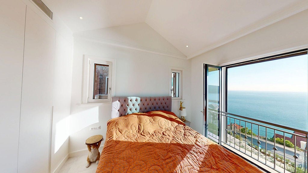 Bright bedroom with a bed and panoramic sea view in an apartment, Luštica, Montenegro.