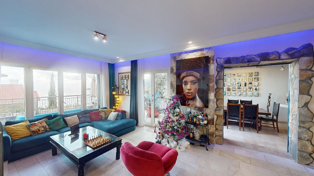 Living room in a townhouse in Luštica, Montenegro: blue sofa, stone finish, sea view, and stylish interior.
