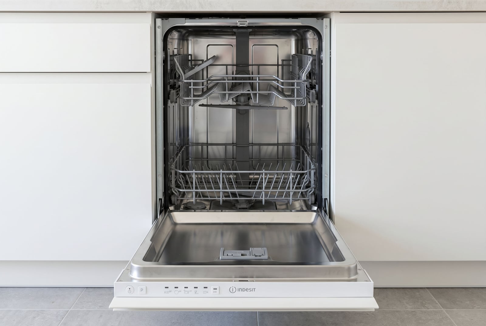 Built-in Indesit dishwasher in a modern white kitchen of an apartment in Becici, Montenegro.