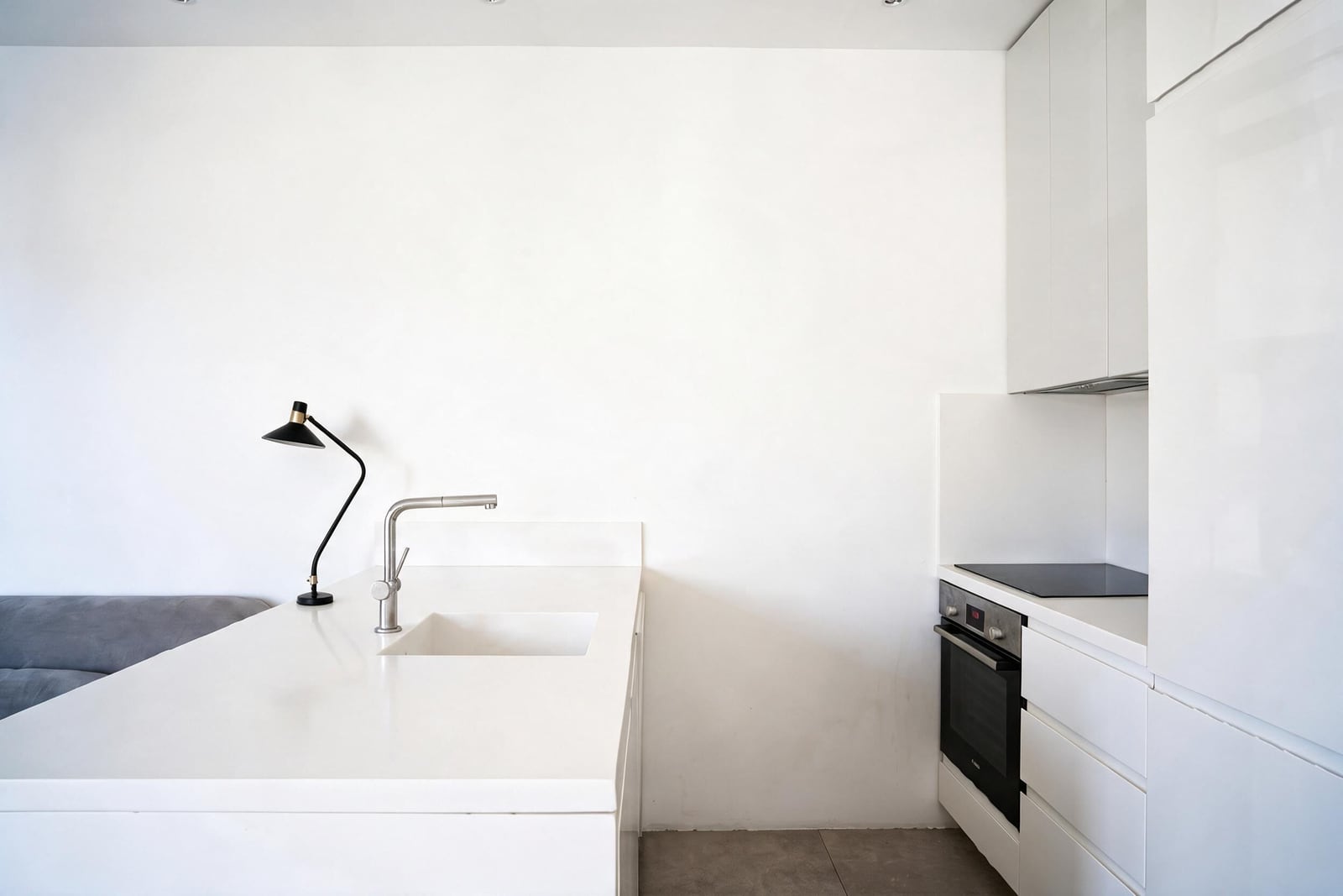 White modern kitchen with an island and built-in appliances in an apartment in Tivat, Montenegro