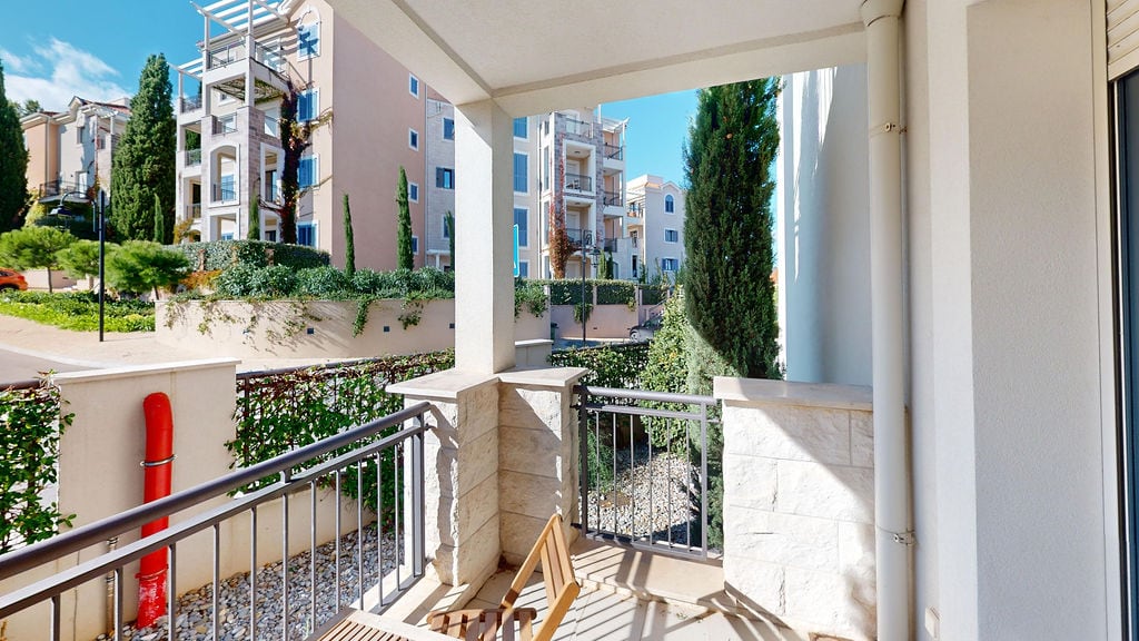 Cozy balcony with stone finish and view of the residential complex in Luštica, Montenegro.