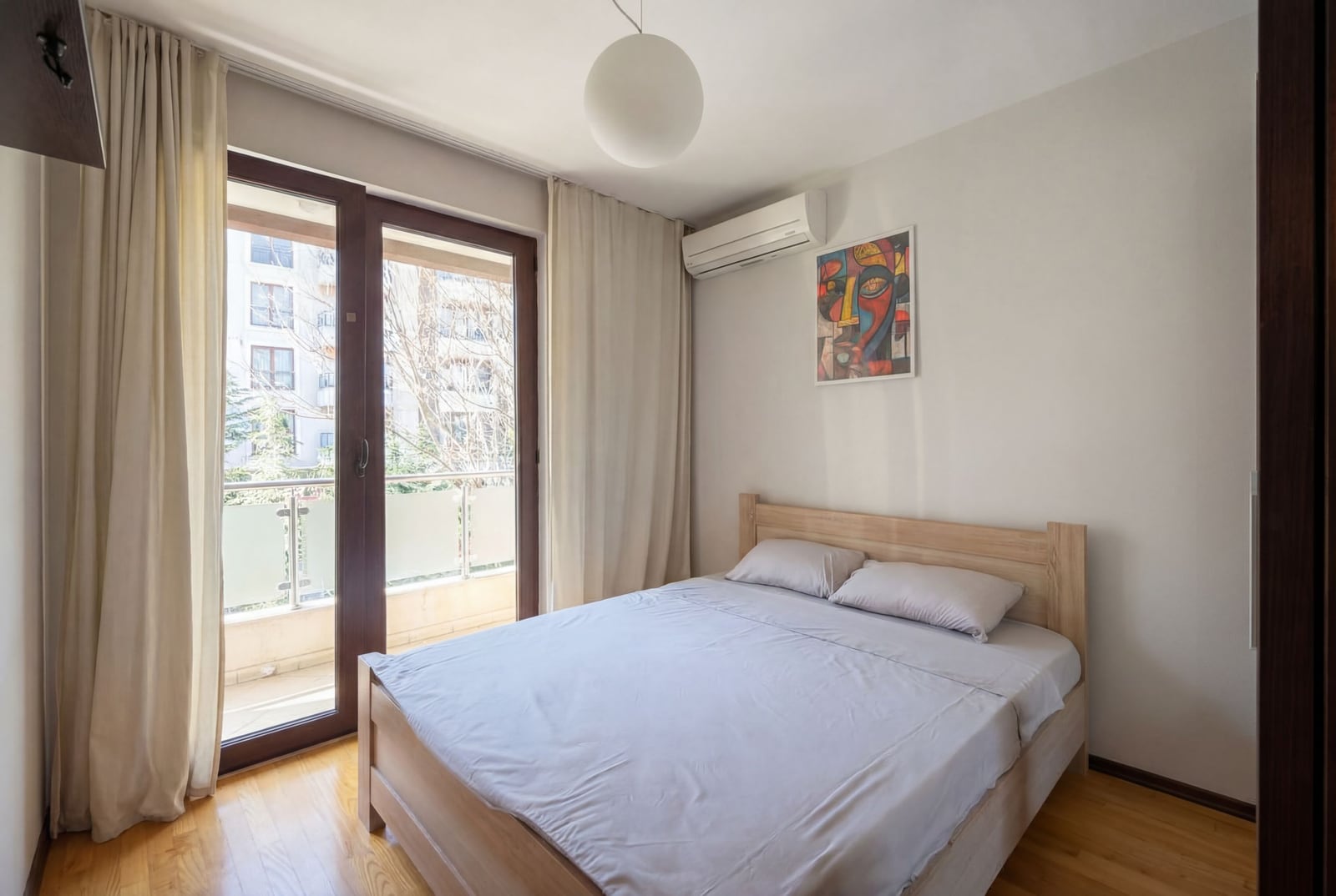 Bright bedroom with a double bed and access to the balcony in an apartment, Budva, Montenegro.