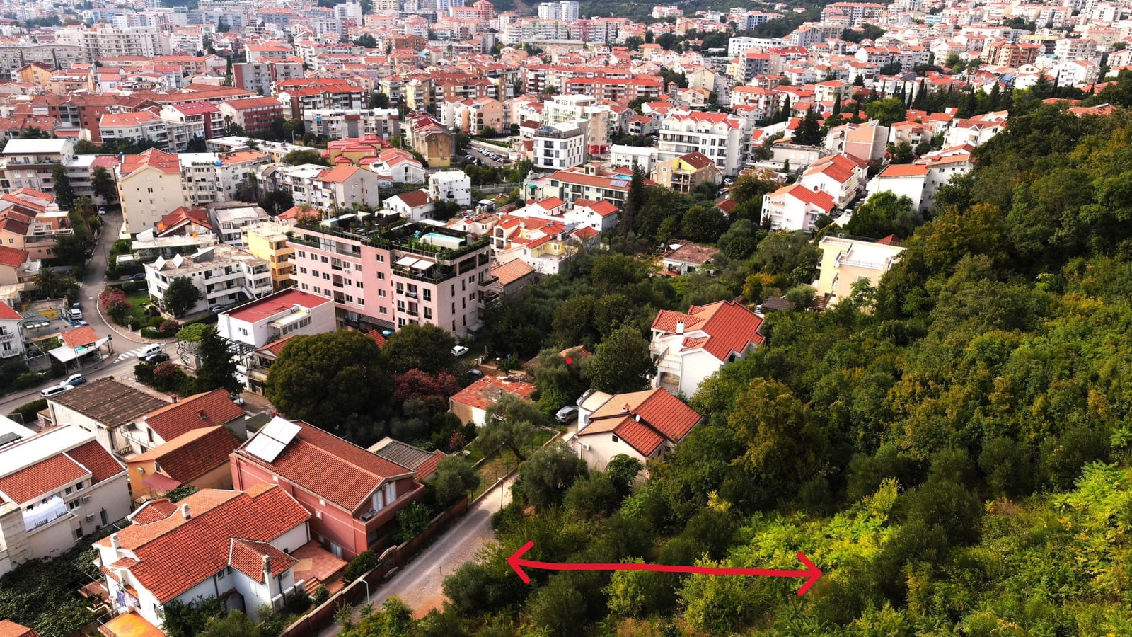 Building plot in Budva, Montenegro: panoramic view of the city, residential area, and green zone.