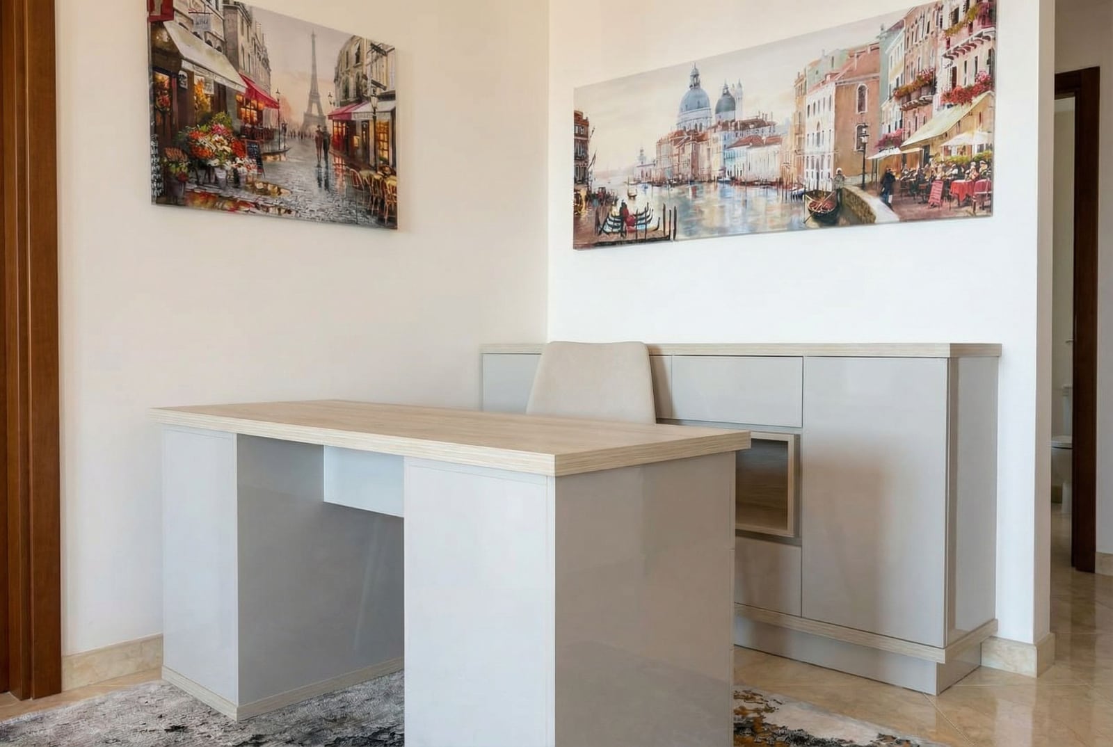 Work area with a modern desk and cabinet in an apartment, Becici, Montenegro. Bright interior with paintings.
