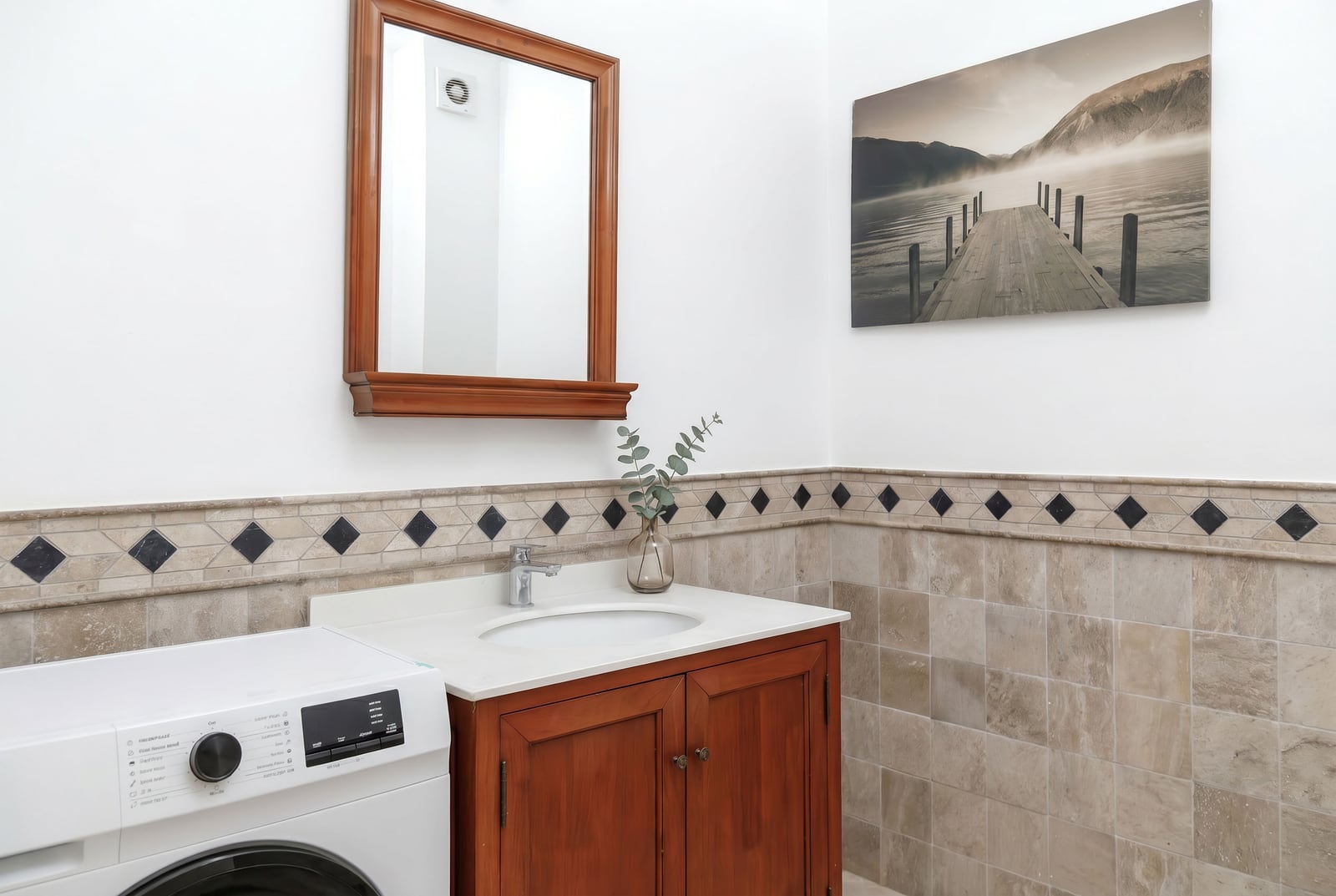 Bathroom in an apartment in Risan, Montenegro: wooden vanity with sink, mirror, and washing machine.