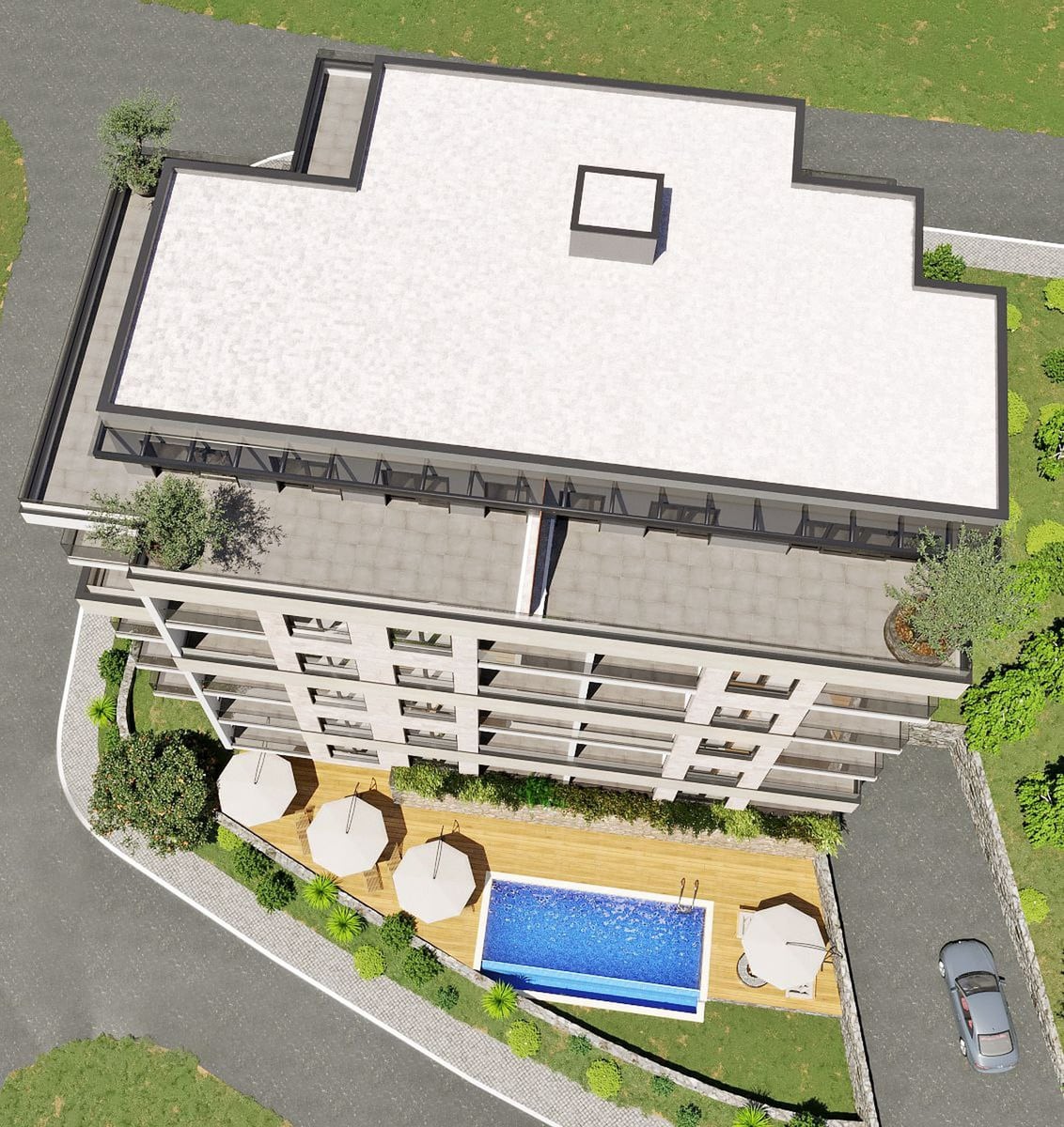 Aerial view of a multi-story building with a flat roof, blue pool, and wooden deck with umbrellas.