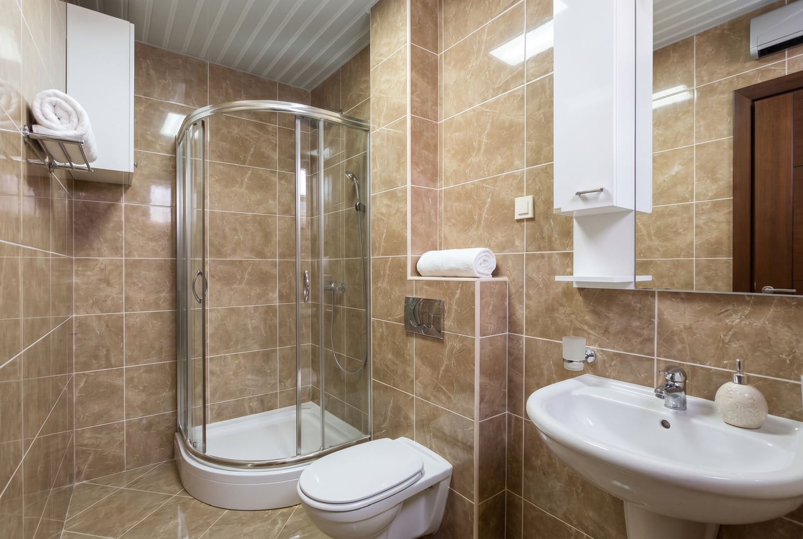 Modern bathroom with a shower cabin in an apartment, Budva, Montenegro: marble-look tiles, plumbing fixtures, and furniture.