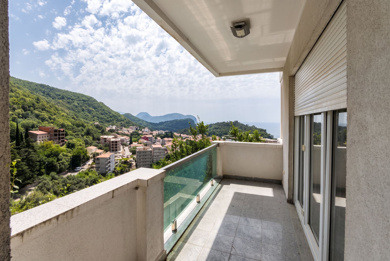 Spacious balcony with panoramic views of the mountains and sea in an apartment in Petrovac, Montenegro.