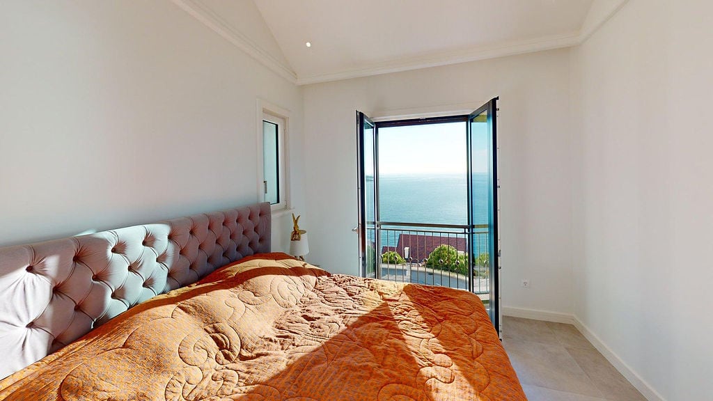 Bedroom in an apartment in Luštica, Montenegro: double bed with an upholstered headboard and panoramic view of the Adriatic Sea.
