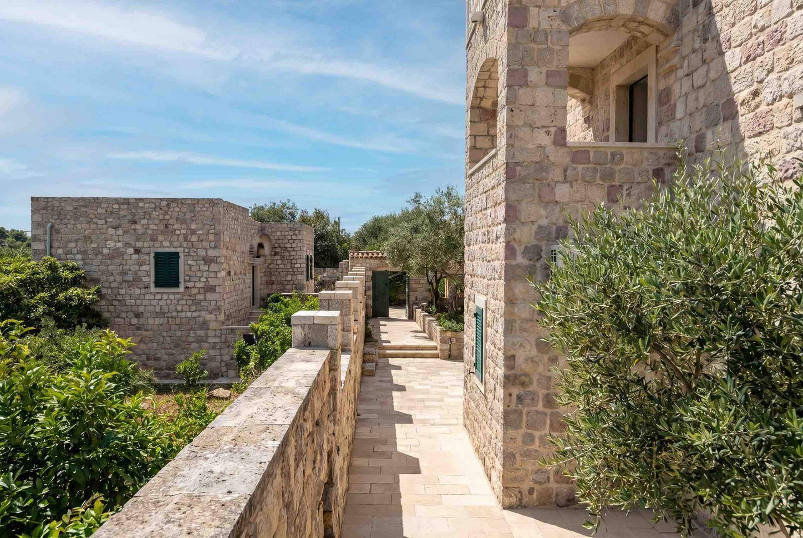 Stone house in Mediterranean style with terrace and garden in Luštica, Montenegro. View of the facade and courtyard.