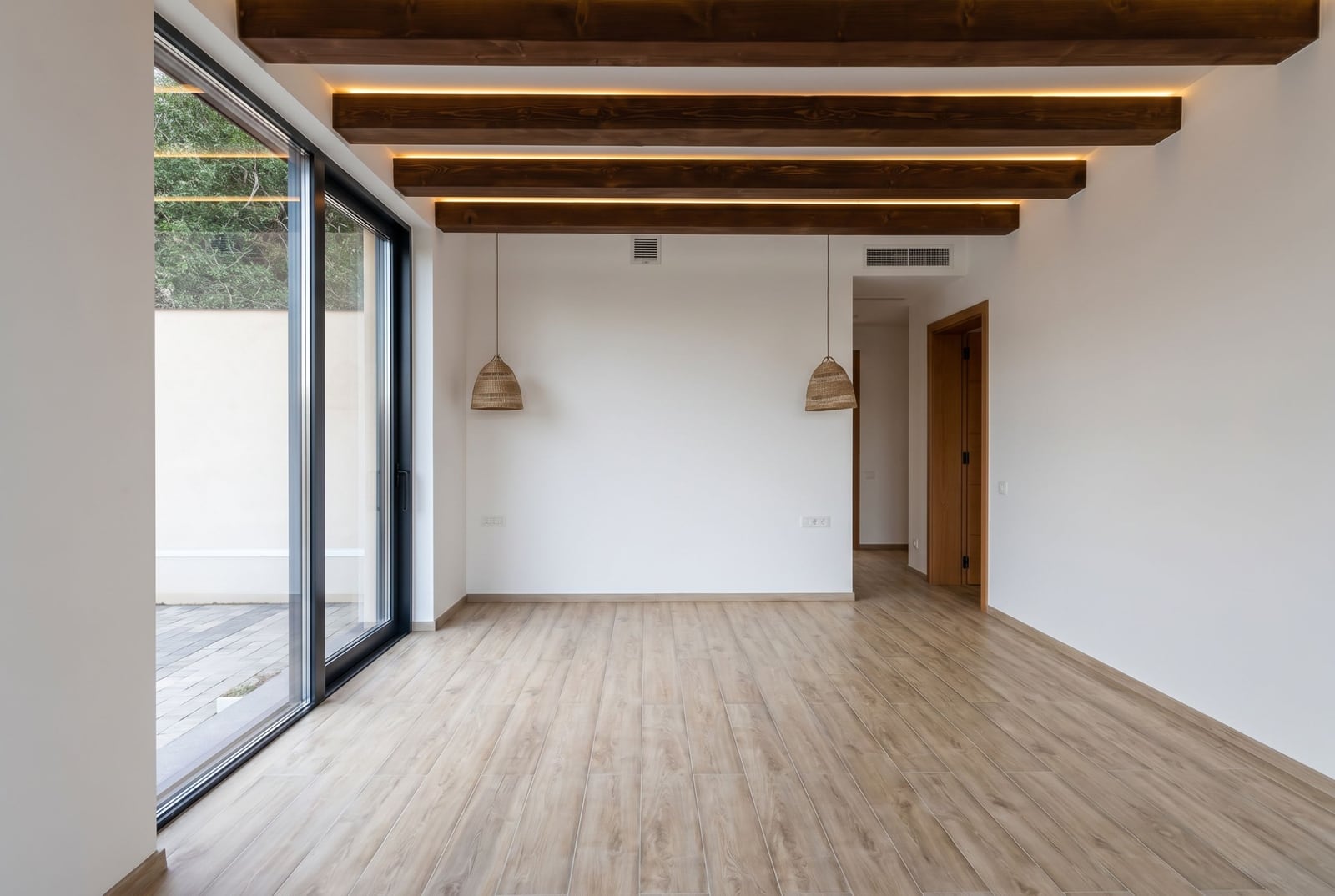 Living room in a villa in Kavac, Montenegro: panoramic windows, wooden ceiling beams, and modern finishes.