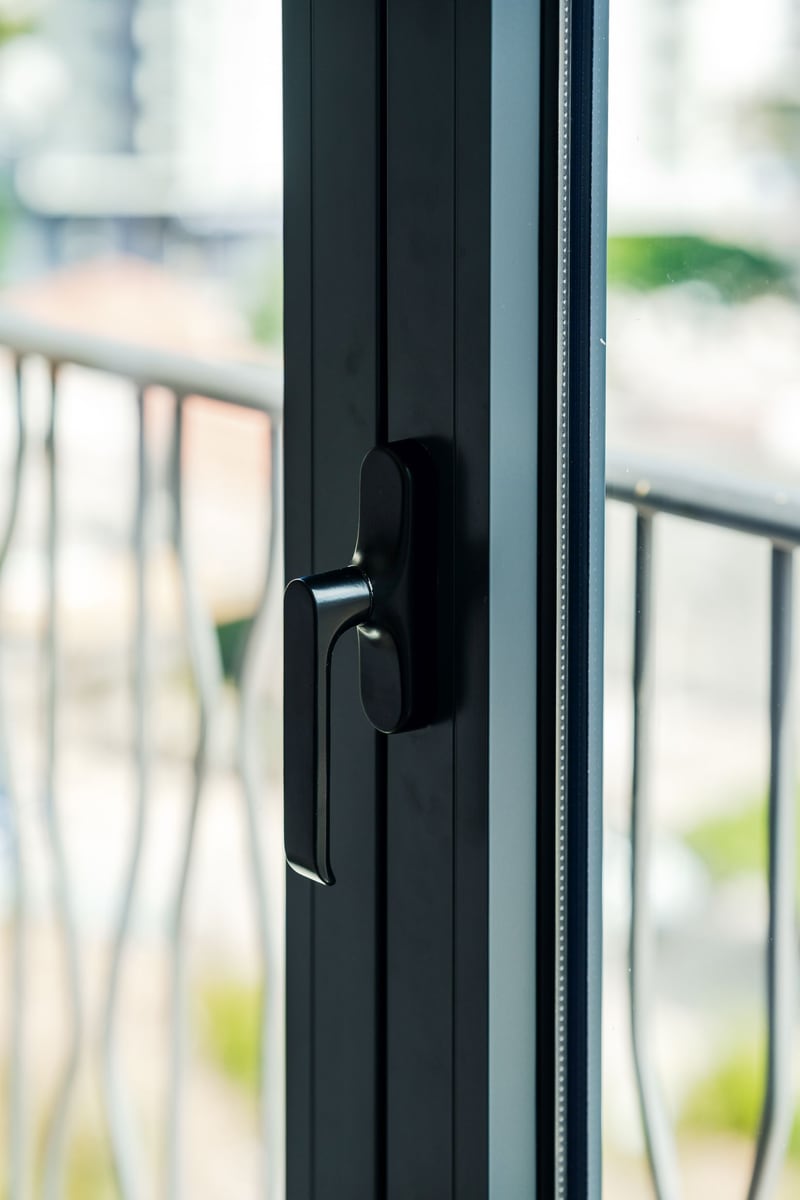 Modern black aluminum window frame and balcony door in a residential complex in Budva, Montenegro.