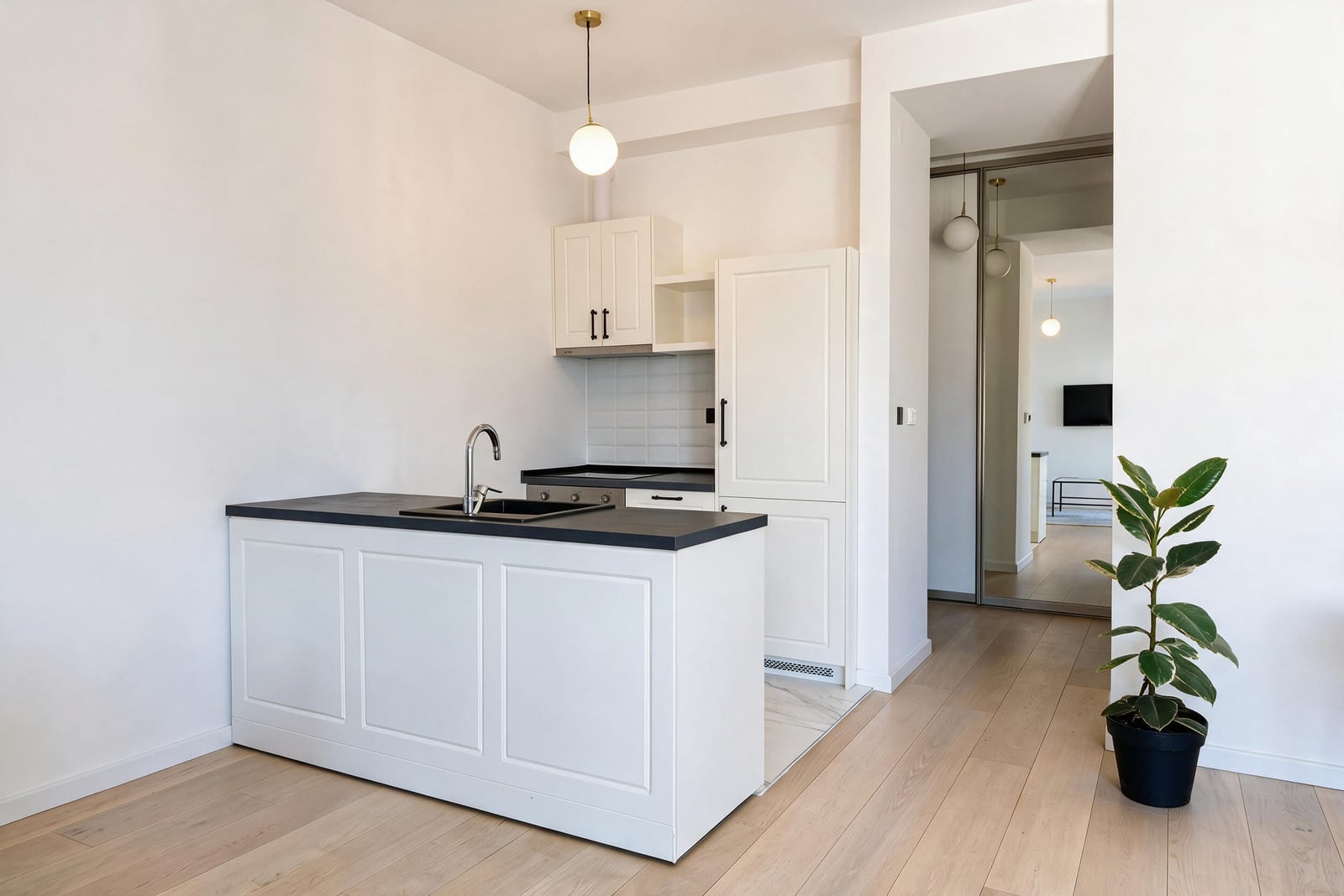 White kitchen with an island and black countertop in a new apartment in Tivat, Montenegro
