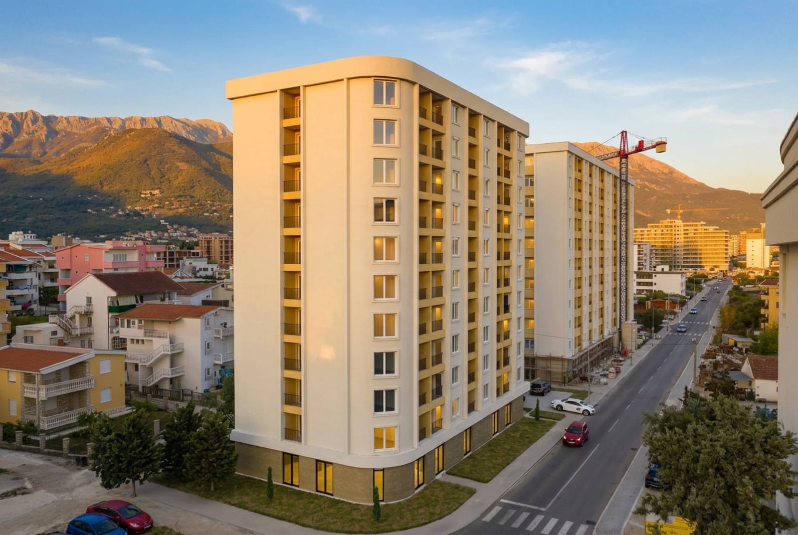 New residential complex in Bar, Montenegro: a modern multi-story building with balconies against a mountain backdrop.