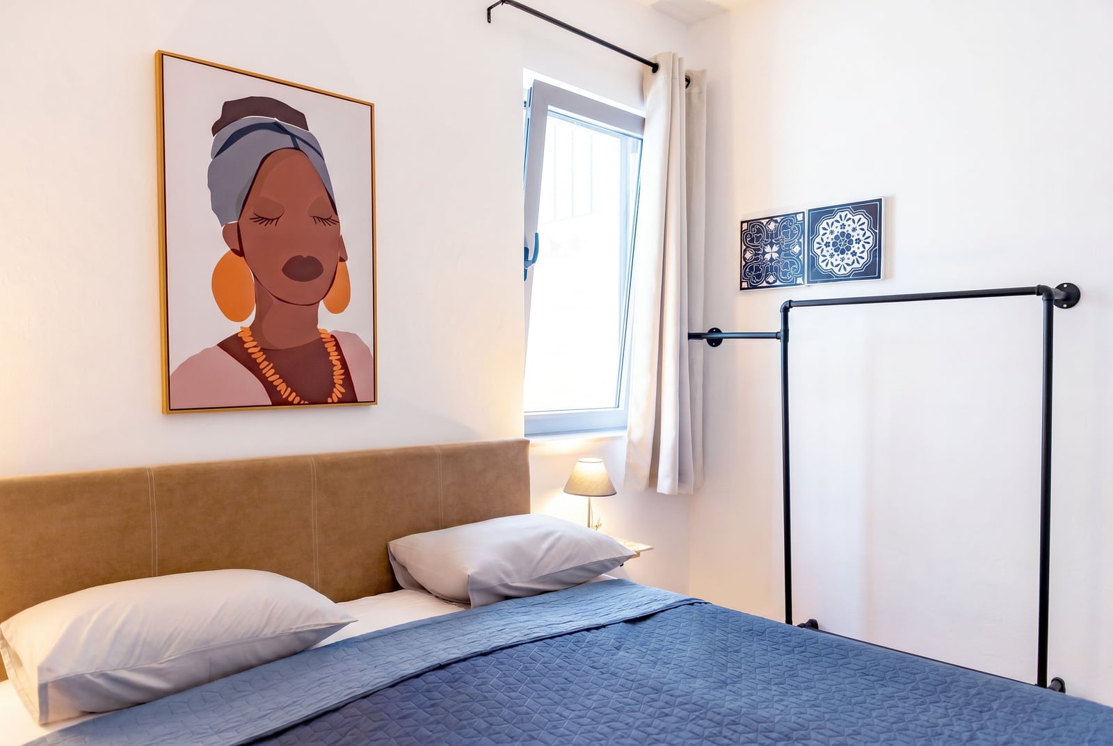 Modern bedroom in an apartment in Risan, Montenegro: double bed, stylish decor, and an open wardrobe.