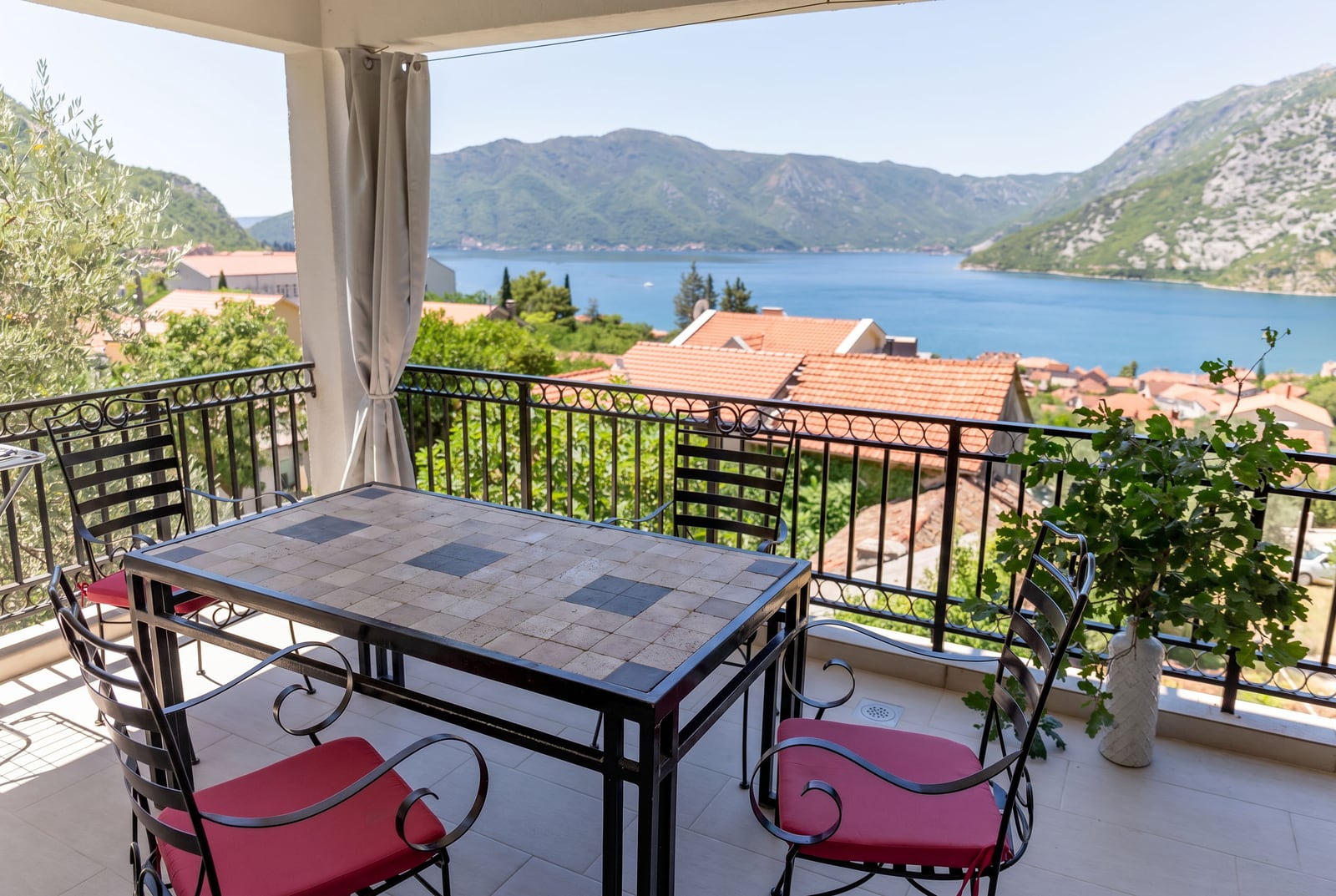 Terrace with wrought iron furniture and panoramic views of the Bay of Kotor and mountains, apartment in Risan, Montenegro.