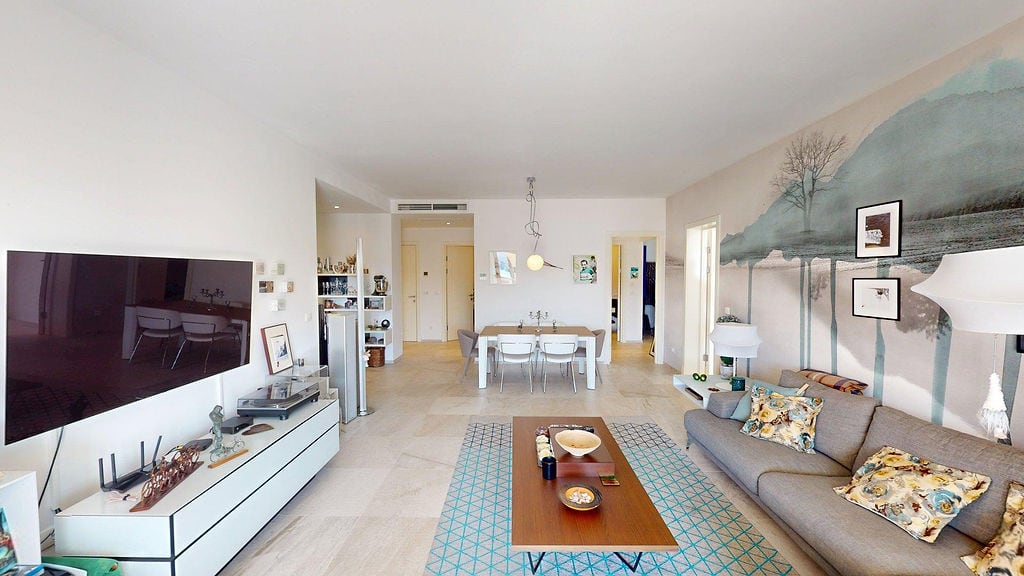 Modern living room with dining area in an apartment, Luštica, Montenegro: stylish furniture, light interior, and decor.
