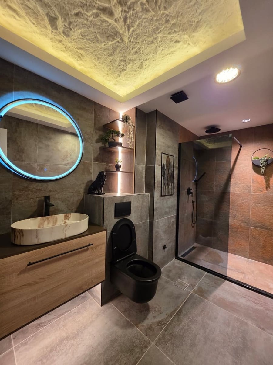 Modern bathroom in an apartment in Bečići, Montenegro: stylish finishes, a shower cabin, and designer lighting.