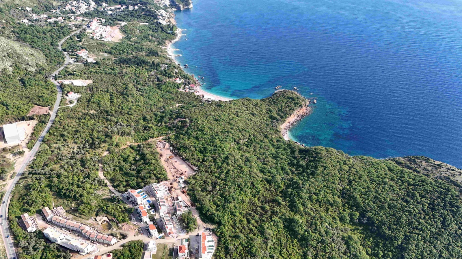 Aerial view of a land plot in Reževići, Montenegro: the Adriatic Sea coast and green landscape.