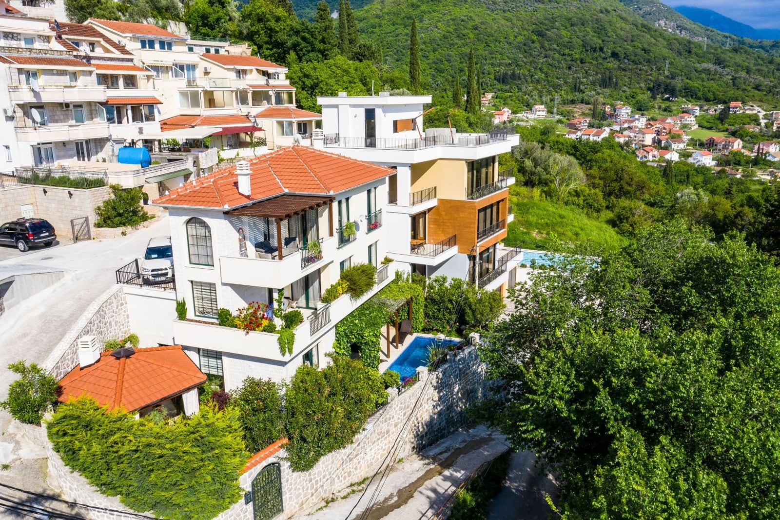 Villa in Tivat, Montenegro: modern house with a pool, terraces, and views of green mountains, top view.