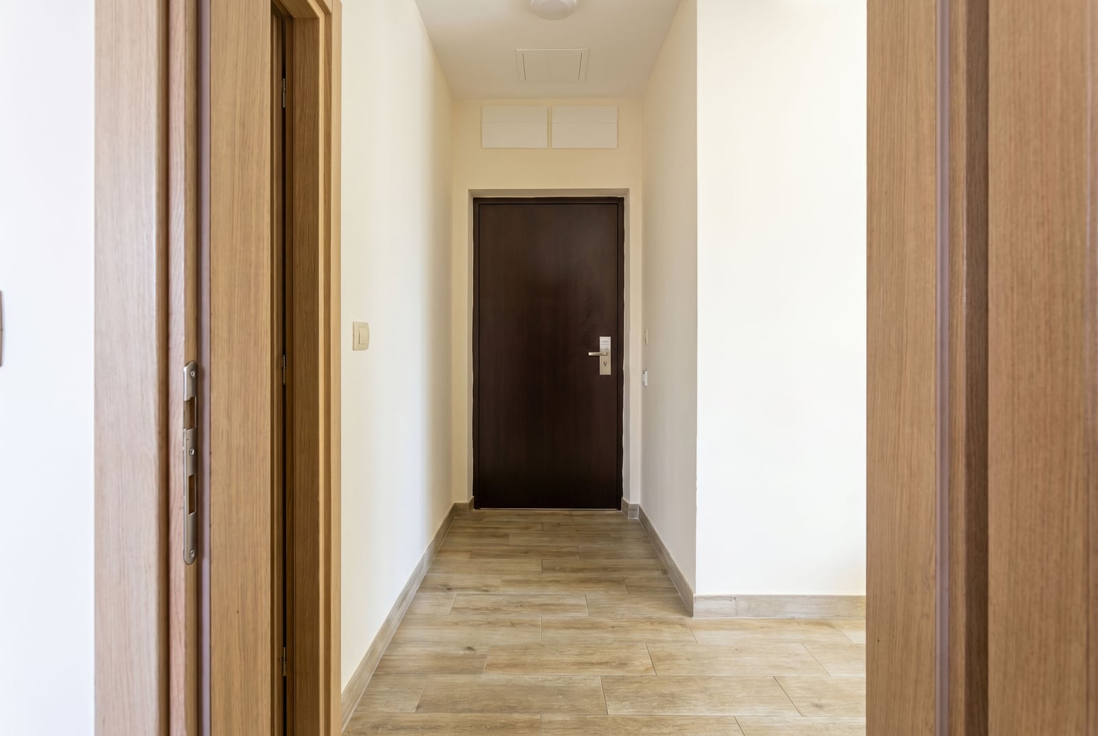 Bright hallway with wooden doors and floor tiles in a modern apartment in Bečići, Montenegro.