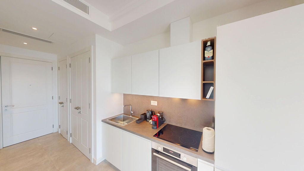 Modern white kitchen in an apartment, Luštica, Montenegro: built-in appliances, hob, and stylish interior.
