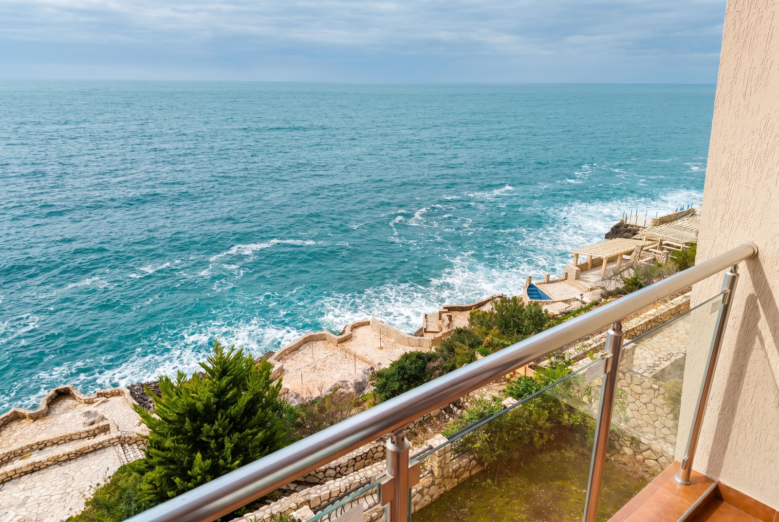 View from the apartment balcony in Bar, Montenegro: seaside terrace, stone finishes, panoramic sea view.