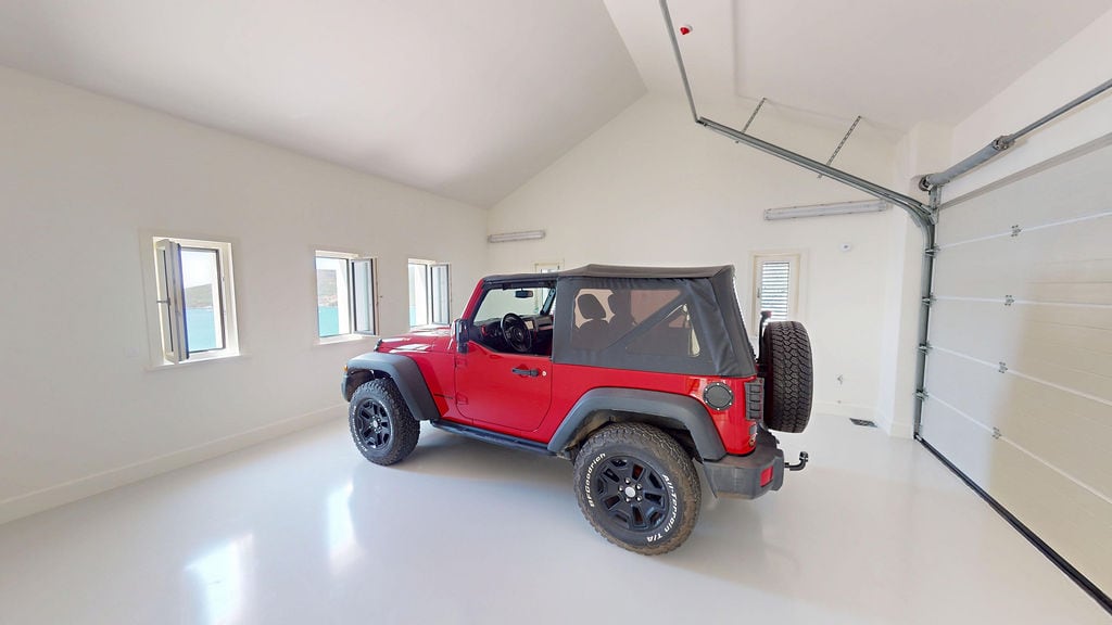 Spacious bright garage with a red SUV and a sea view, villa in Luštica, Montenegro.
