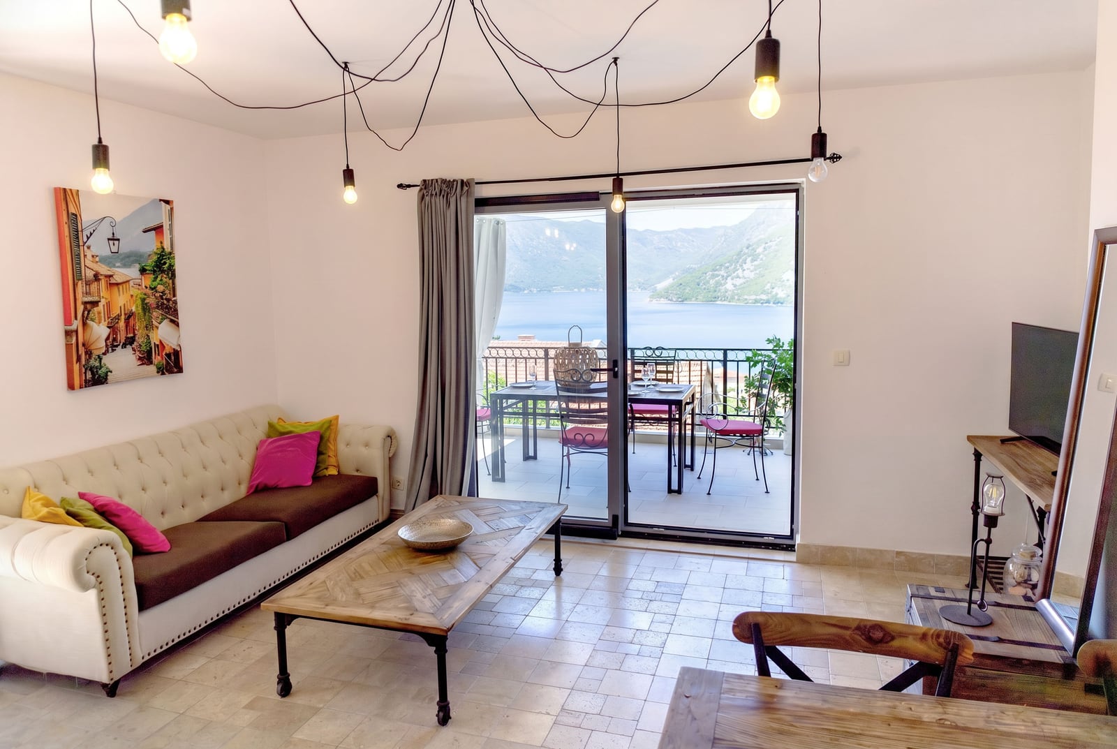 Living room in an apartment in Risan, Montenegro: bright interior, terrace with a view of the Bay of Kotor and the mountains.