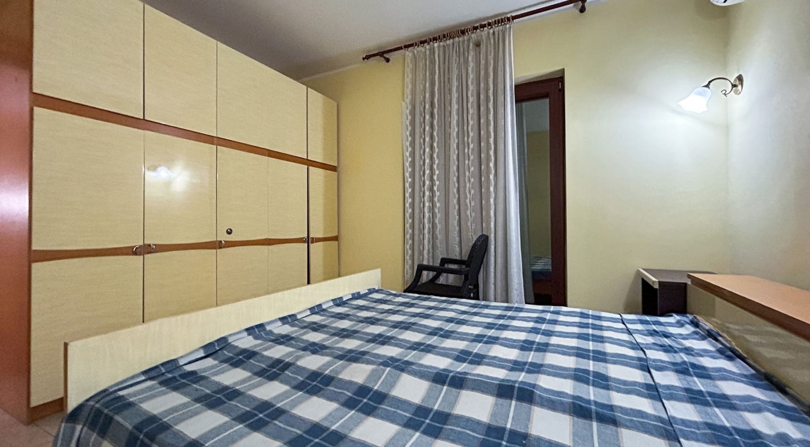 Bedroom in a villa in Dobrota, Montenegro: double bed, large built-in wardrobe, and access to the balcony.