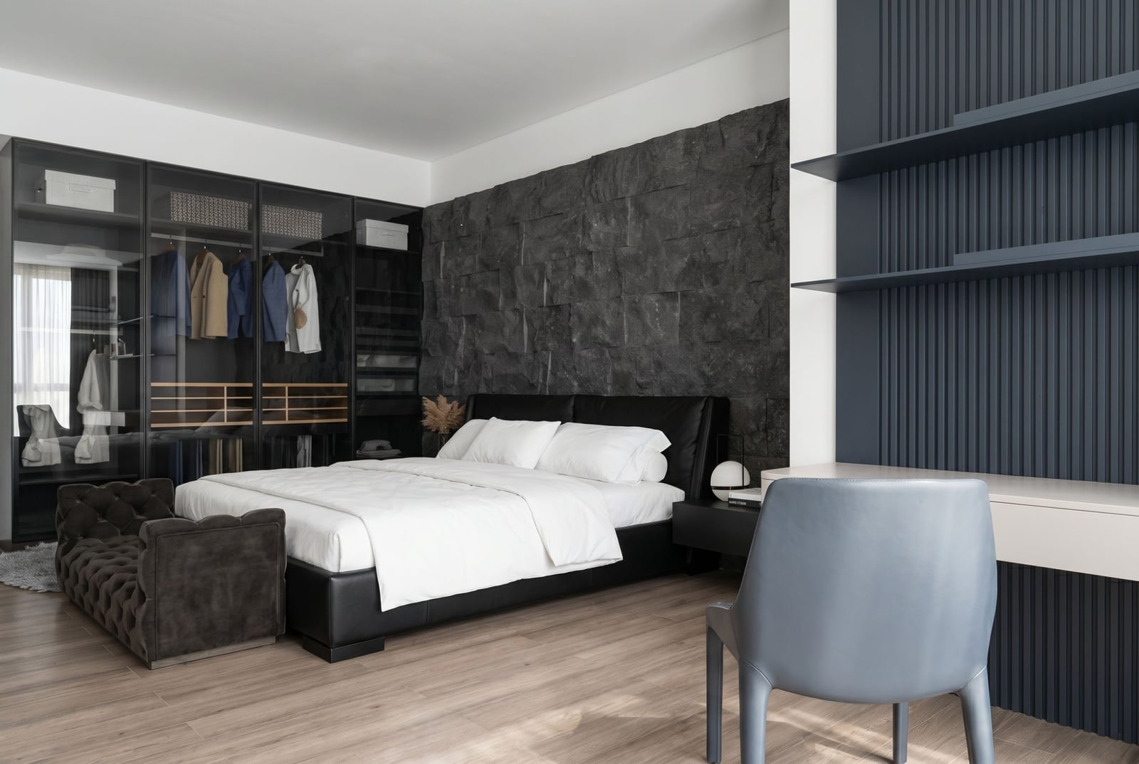 Modern bedroom in an apartment in Bečići, Montenegro: double bed, stone wall, and built-in wardrobe.