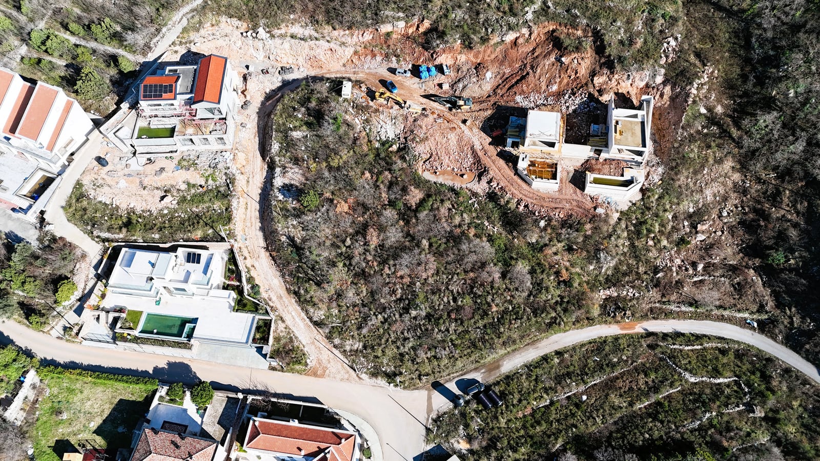 Aerial view of villas under construction and land plot in Blizikuće, Montenegro: residential complex in the development stage.
